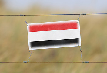 Image showing Border fence - Old plastic sign with a flag