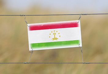 Image showing Border fence - Old plastic sign with a flag