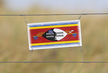 Image showing Border fence - Old plastic sign with a flag