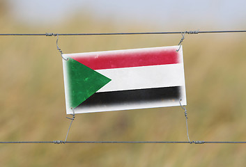 Image showing Border fence - Old plastic sign with a flag