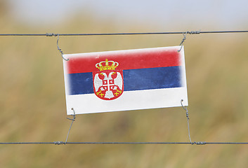 Image showing Border fence - Old plastic sign with a flag