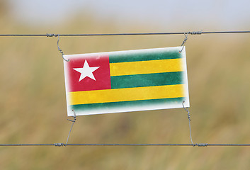 Image showing Border fence - Old plastic sign with a flag