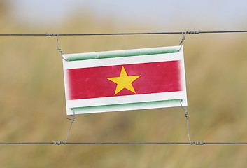 Image showing Border fence - Old plastic sign with a flag