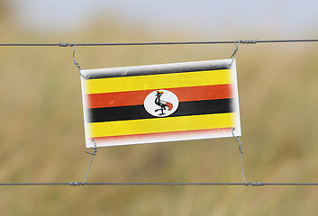 Image showing Border fence - Old plastic sign with a flag