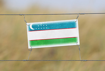 Image showing Border fence - Old plastic sign with a flag