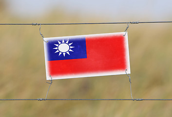 Image showing Border fence - Old plastic sign with a flag