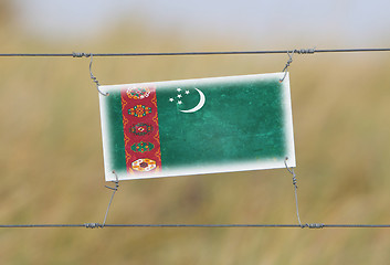 Image showing Border fence - Old plastic sign with a flag