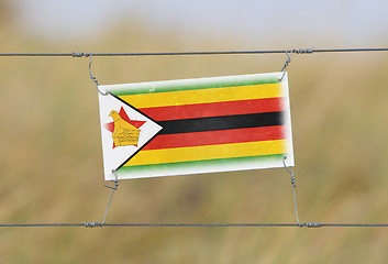 Image showing Border fence - Old plastic sign with a flag