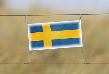 Image showing Border fence - Old plastic sign with a flag