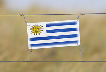 Image showing Border fence - Old plastic sign with a flag