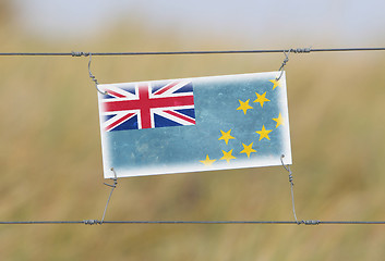 Image showing Border fence - Old plastic sign with a flag