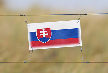 Image showing Border fence - Old plastic sign with a flag