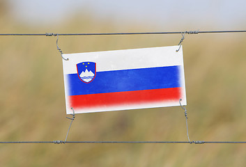 Image showing Border fence - Old plastic sign with a flag