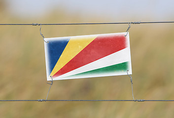 Image showing Border fence - Old plastic sign with a flag