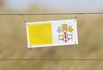 Image showing Border fence - Old plastic sign with a flag