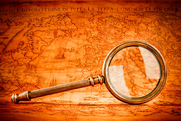 Image showing Vintage magnifying glass lies on an ancient world map