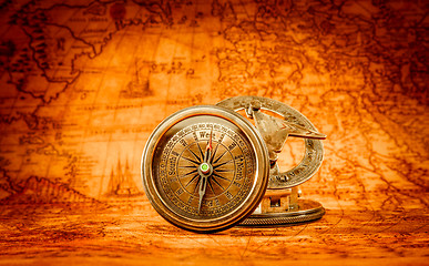 Image showing Vintage compass lies on an ancient world map.