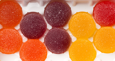 Image showing Round jelly sprinkled with sugar in a plastic box.