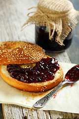 Image showing Homemade bagel with jam and tea spoon.