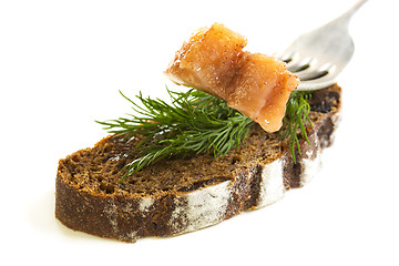 Image showing Slice on a fork herring and black bread.