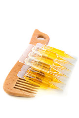 Image showing Hair oil and wooden comb.