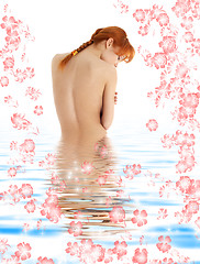 Image showing healthy redhead in blue water with flowers