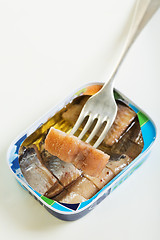 Image showing Tin and slice of herring on a fork.