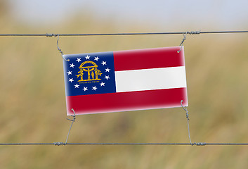 Image showing Border fence - Old plastic sign with a flag