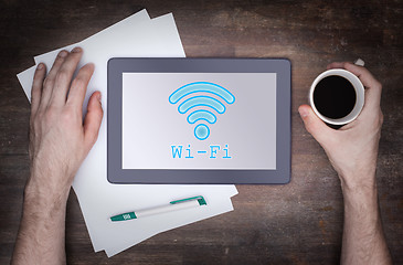 Image showing Tablet with Wi-Fi connection on a wooden desk