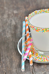 Image showing Glass of milk with striped straws