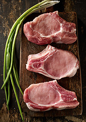 Image showing fresh raw meat on wooden cutting board