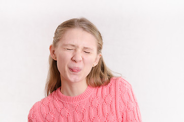 Image showing Young girl closed her eyes and pulled language