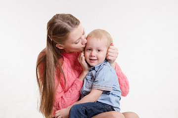 Image showing Young mother kissing her son three years