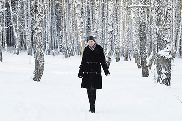 Image showing The woman in a black fur coat costs in the birch wood in the win