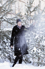 Image showing The cheerful woman in a black fur coat costs at snow-covered pin