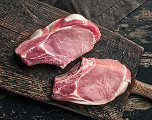 Image showing fresh raw meat on wooden cutting board