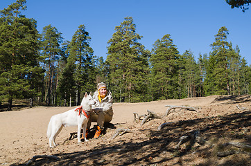 Image showing The woman with a white dog in a wood