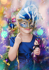 Image showing Little blond girl with a carnival mask