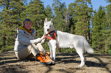 Image showing The woman with a white dog in a wood