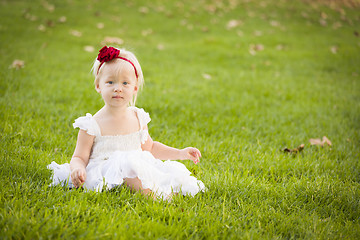 Image showing Adorable Little Girl Wearing White Dress In A Grass Field