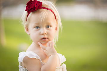 Image showing Adorable Little Girl Wearing White Dress In A Grass Field