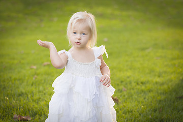 Image showing Adorable Little Girl Wearing White Dress In A Grass Field