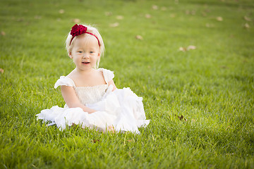 Image showing Adorable Little Girl Wearing White Dress In A Grass Field