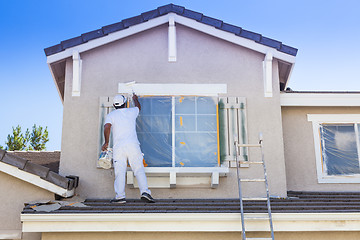 Image showing House Painter Painting the Trim And Shutters of Home