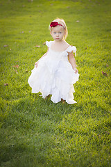 Image showing Adorable Little Girl Wearing White Dress In A Grass Field