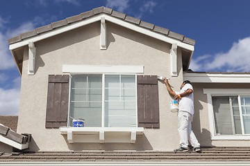 Image showing House Painter Painting the Trim And Shutters of Home