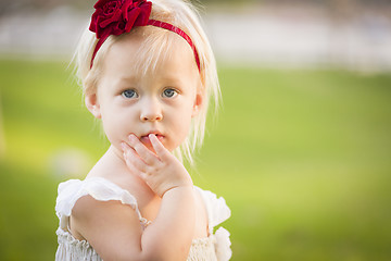 Image showing Adorable Little Girl Wearing White Dress In A Grass Field