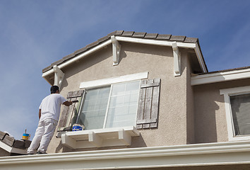 Image showing House Painter Painting the Trim And Shutters of Home