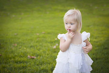 Image showing Adorable Little Girl Wearing White Dress In A Grass Field