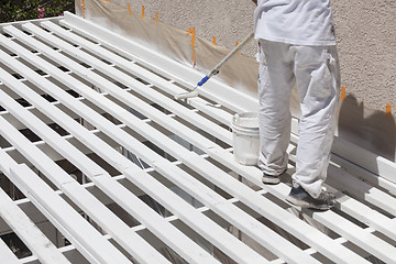 Image showing Painter Rolling White Paint Onto Top of Patio Cover